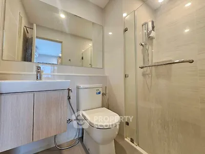 Modern bathroom with glass shower and sleek fixtures in a contemporary apartment.