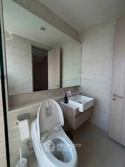 Modern bathroom with sleek fixtures and large mirror in a contemporary home.