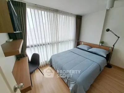 Modern bedroom with large windows and stylish decor in a cozy apartment.