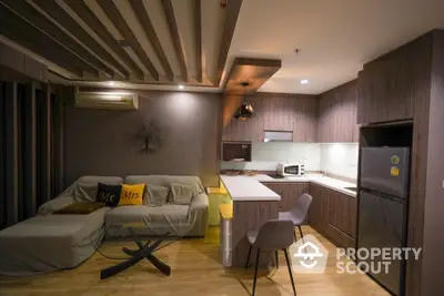 Cozy modern studio apartment with integrated living space, featuring sleek kitchen with built-in appliances and comfortable living area.