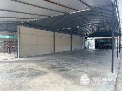 Spacious covered parking area with concrete flooring and metal roof structure