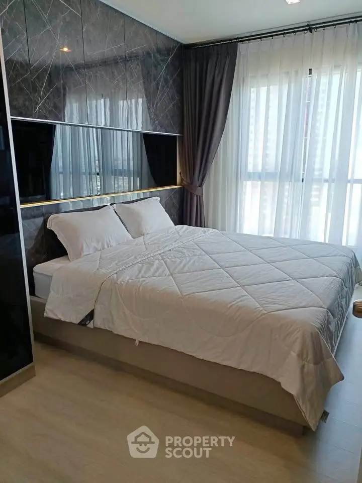 Modern bedroom with stylish decor and large window for natural light