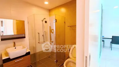 Modern bathroom with glass shower and stylish sink in contemporary home.