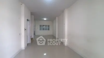 Spacious empty room with tiled flooring and neutral walls, perfect for customization.