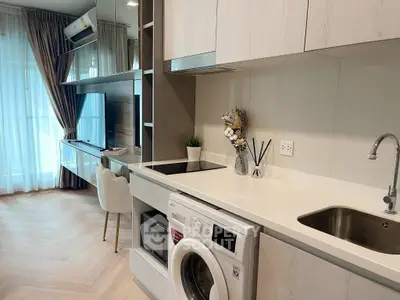 Modern kitchen with washing machine and sleek cabinetry in a stylish apartment