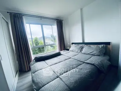 Cozy bedroom with large window and scenic view, featuring a comfortable bed and modern decor.