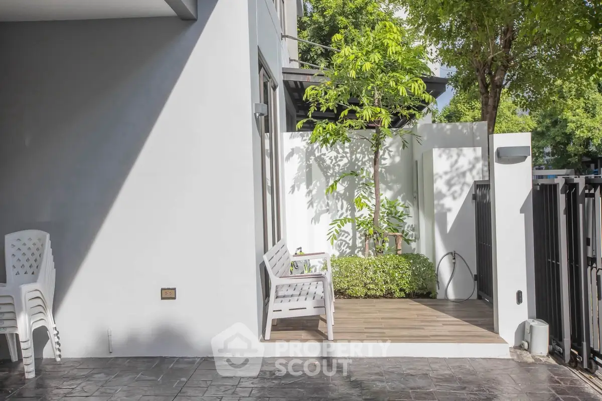 Charming outdoor patio with seating and lush greenery, perfect for relaxation and entertaining.