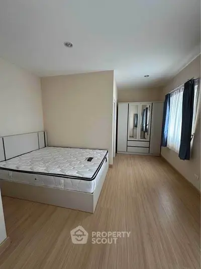 Spacious bedroom with natural light and modern furnishings