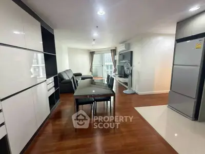 Modern living room with sleek furniture and open kitchen layout in a stylish apartment.