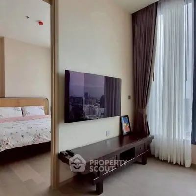 Modern bedroom with large window and wall-mounted TV, featuring elegant decor and natural light.