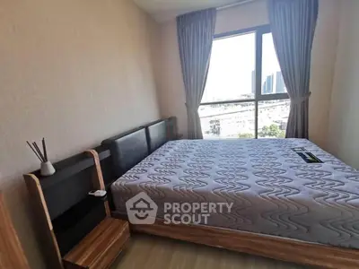 Modern bedroom with large window and stylish furnishings in urban apartment