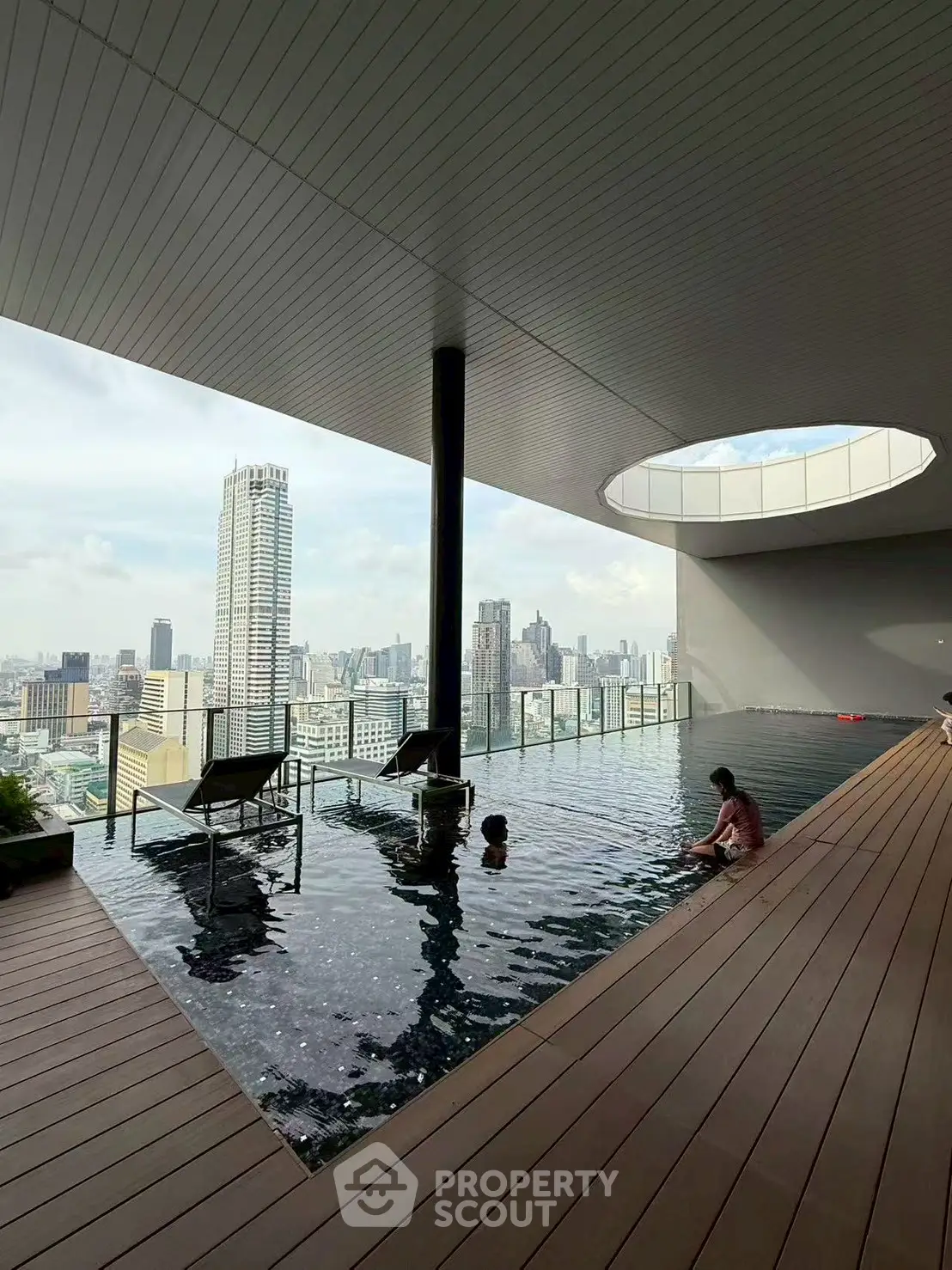 Luxurious rooftop pool with stunning city skyline view, perfect for relaxation and leisure.