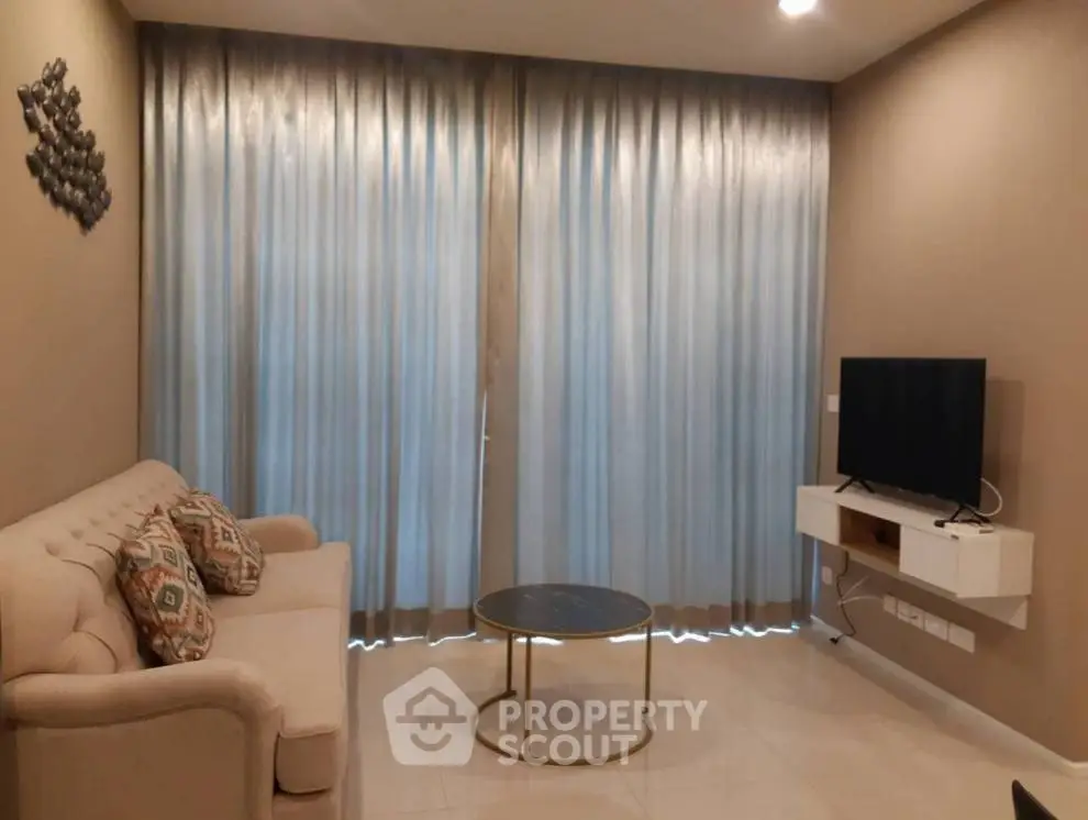 Cozy living room with elegant sofa, modern TV setup, and stylish decor.