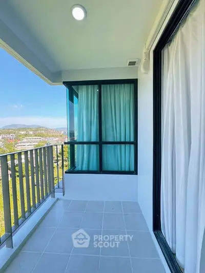 Spacious balcony with stunning view and modern design in high-rise apartment.