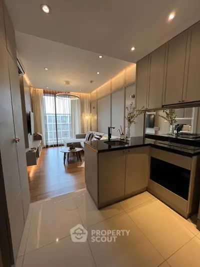 Modern open-layout kitchen and living room with stylish decor and natural light.