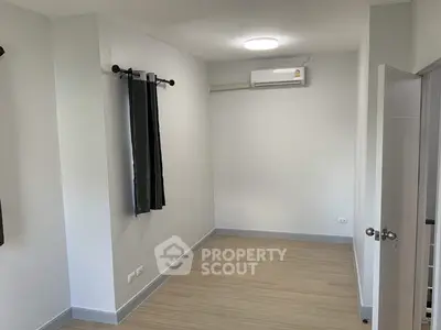Spacious empty room with air conditioning and wooden flooring