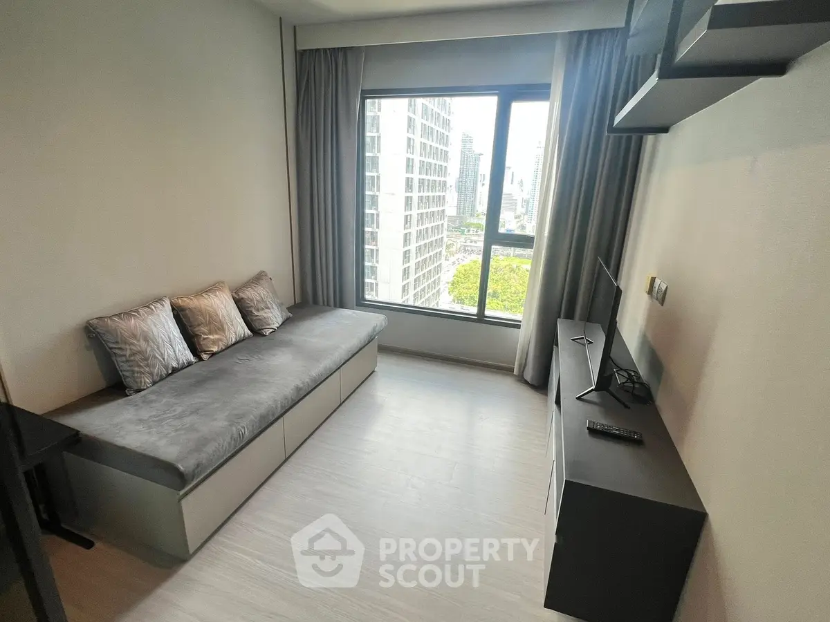 Modern living room with city view, sleek furniture, and large window in urban apartment.