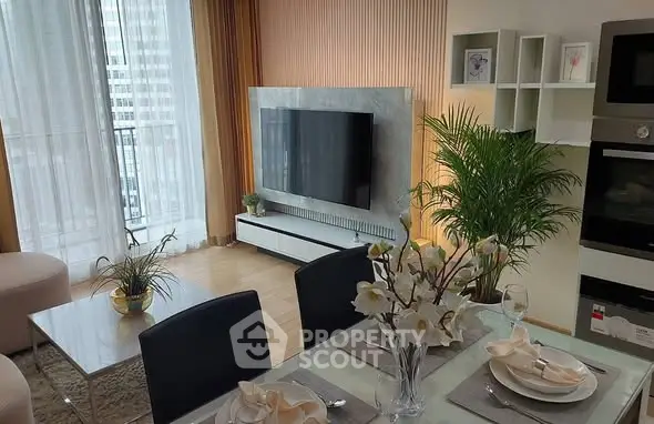 Modern living room with elegant dining area and large TV setup.