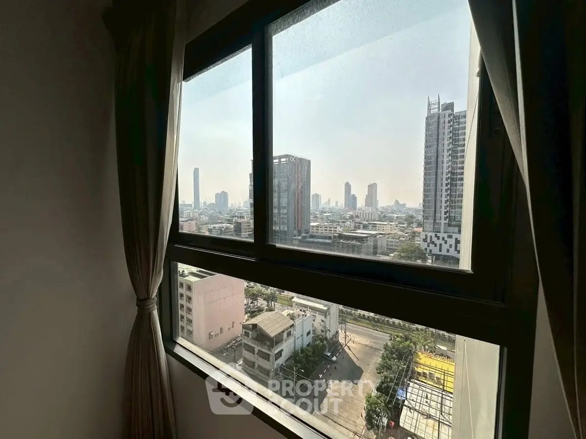 Stunning cityscape view from a high-rise apartment window, showcasing urban skyline and modern architecture.