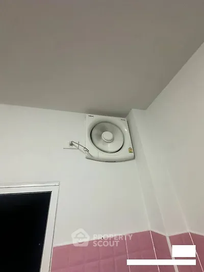 Modern bathroom with wall-mounted ventilation fan and pink tiles