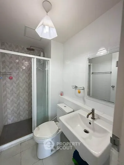 Modern bathroom with shower and sleek fixtures in contemporary apartment.