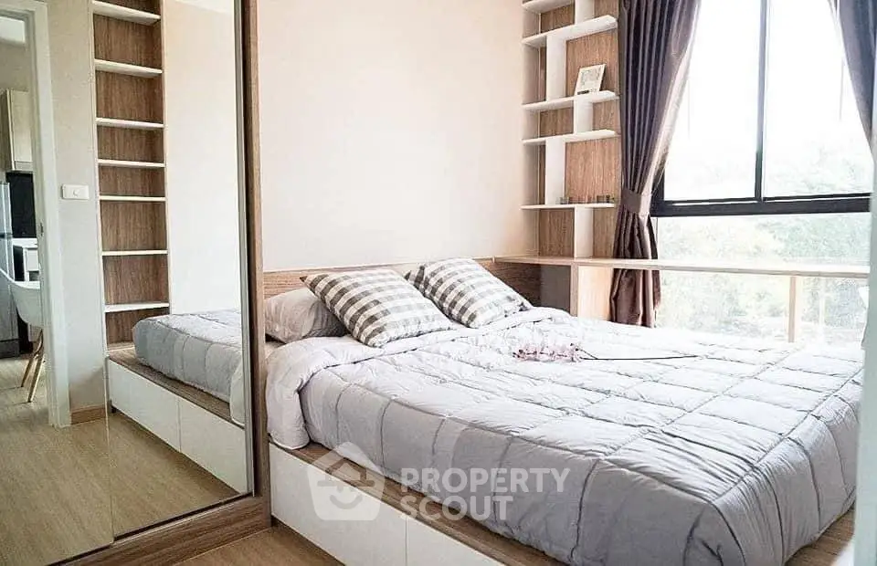 Cozy bedroom with large window and built-in shelves, perfect for natural light lovers.