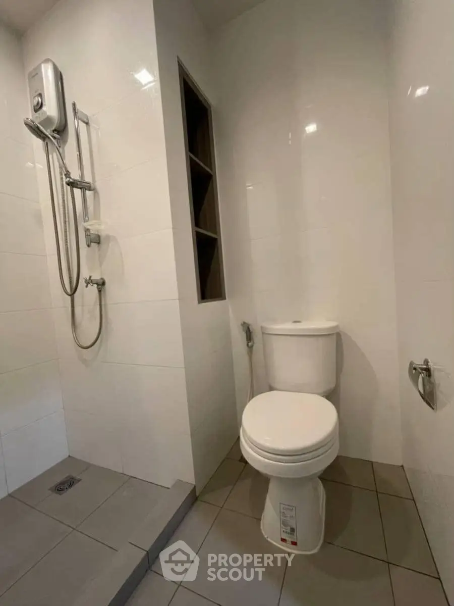 Modern bathroom with shower and toilet in sleek minimalist design.