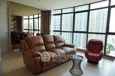 Spacious living room with large windows offering stunning city views and modern furniture.