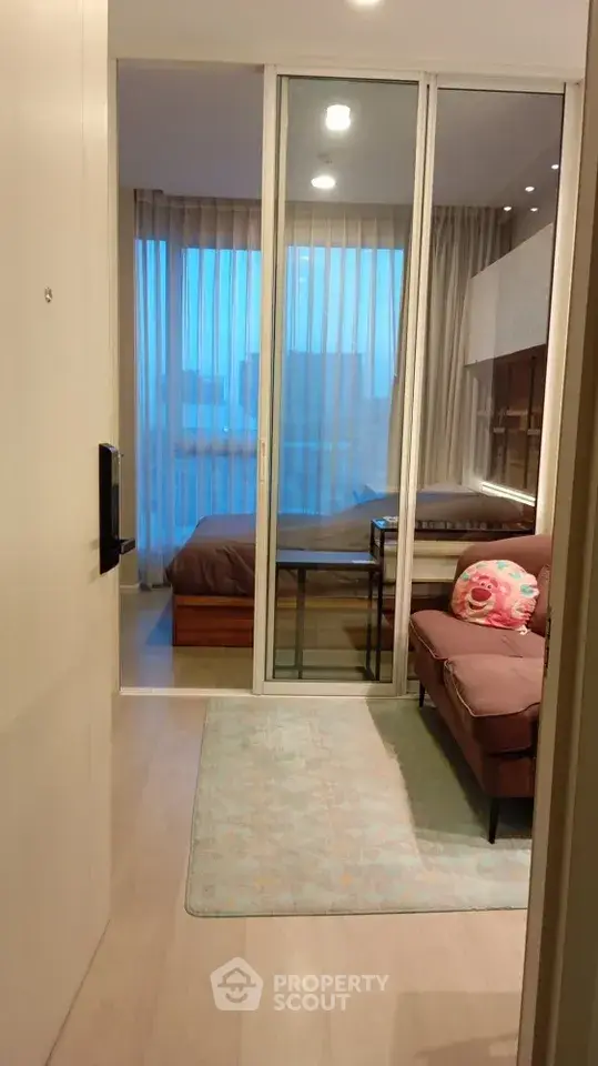 Modern apartment entrance with cozy living area and bedroom view