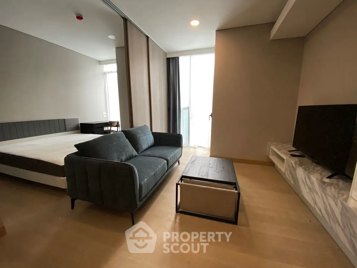 Modern studio apartment with stylish living area and cozy bedroom setup.