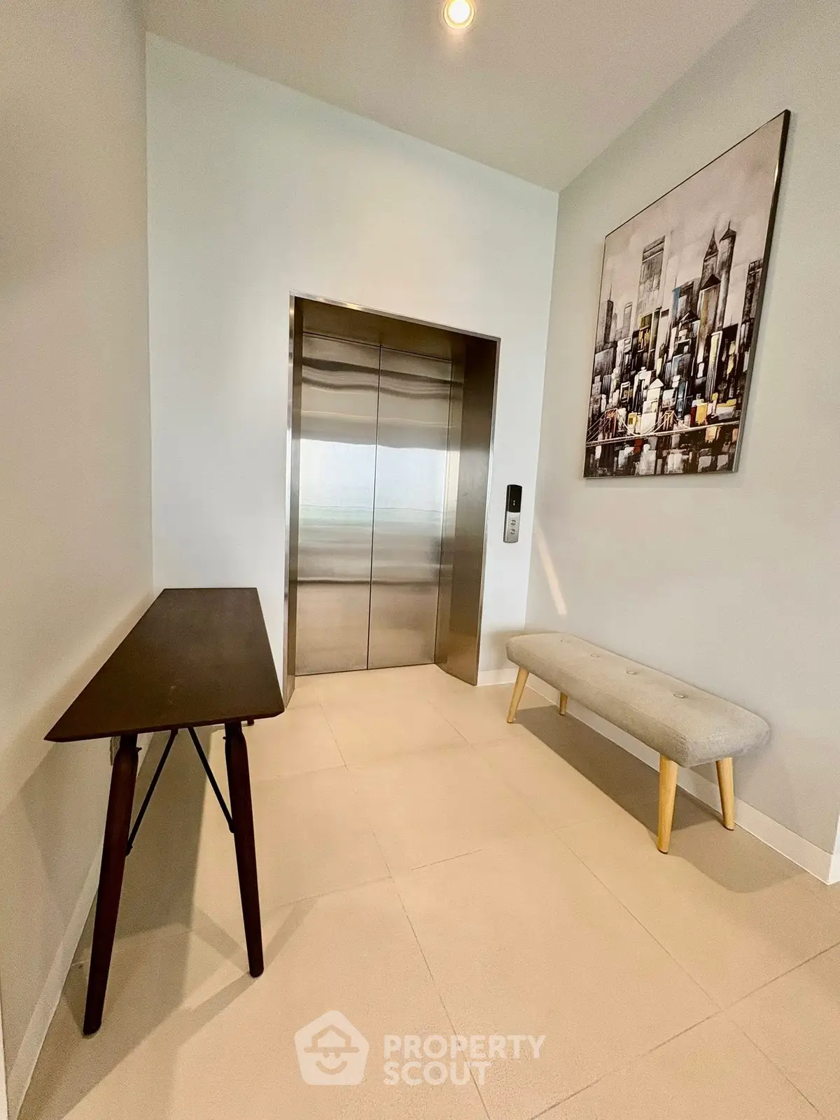 Modern elevator lobby with stylish decor and cityscape artwork.