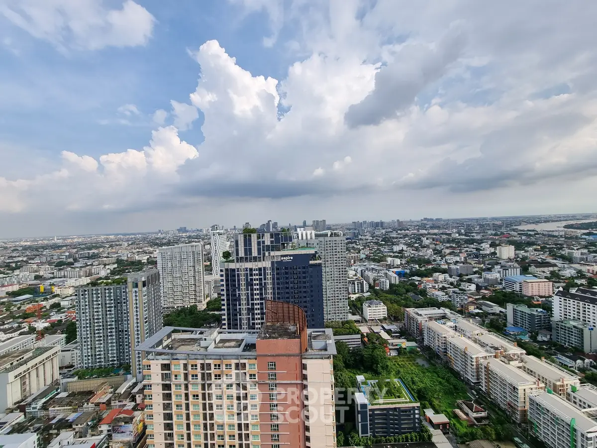 Stunning cityscape view from high-rise building with expansive skyline and lush greenery.