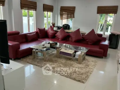 Spacious living room with red sectional sofa and large windows