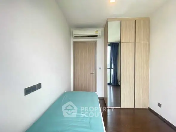 Modern minimalist bedroom with air conditioning and wooden wardrobe