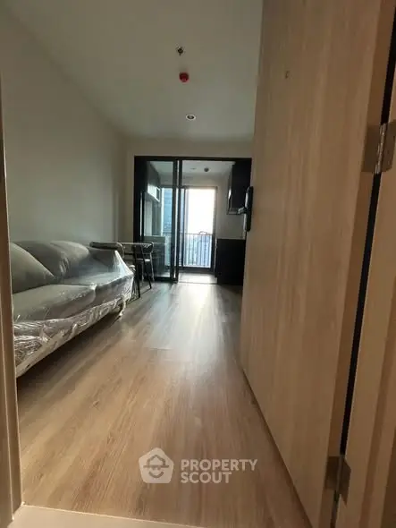 Modern apartment interior with wooden flooring and balcony view
