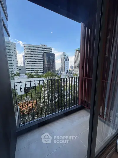 Chic urban balcony with stunning cityscape views in a modern high-rise apartment.