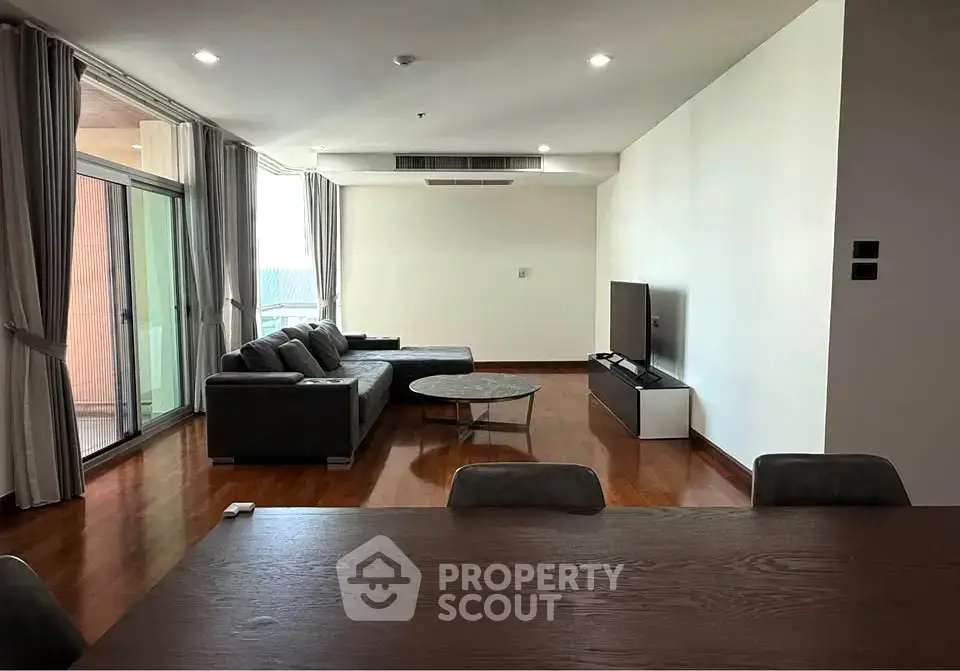 Spacious modern living room with large windows and elegant furnishings