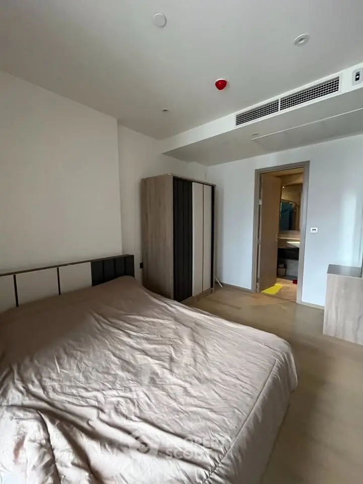 Modern bedroom with minimalist design and neutral tones, featuring a cozy bed and sleek wardrobe.