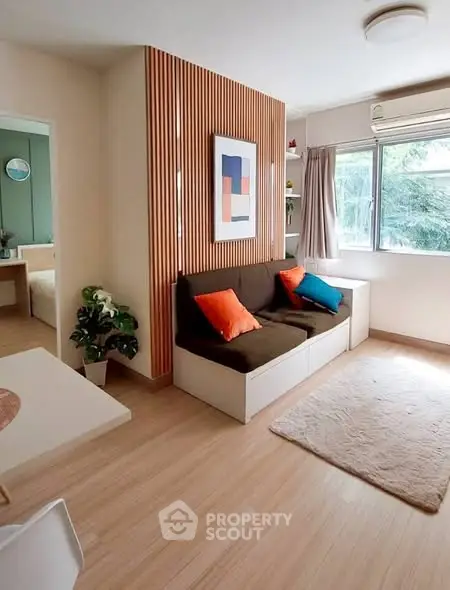 Charming living room with modern decor, wooden accents, and large window offering natural light.