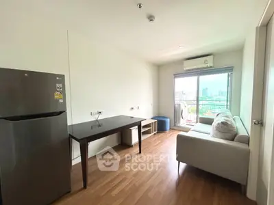 Modern living room with balcony view, featuring sleek furniture and natural light.