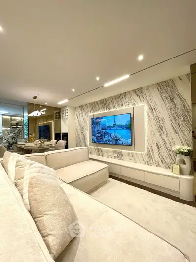 Luxurious living room with modern decor and large TV, perfect for relaxation and entertainment.