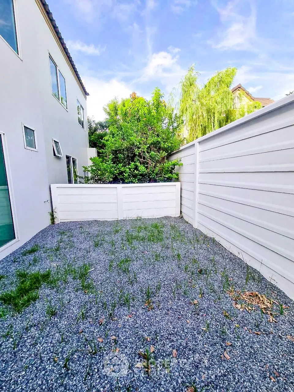 Charming backyard with privacy fence and lush greenery, perfect for relaxation and outdoor activities.