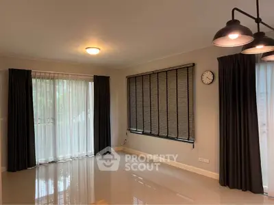 Spacious living room with modern lighting and large windows for natural light.