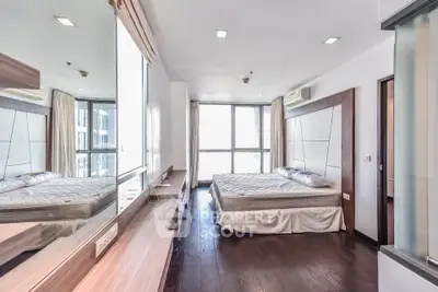 Spacious modern bedroom with large windows and elegant wooden flooring