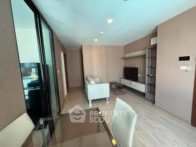 Modern living room with sleek furniture and open layout, featuring a cozy sofa and entertainment center.