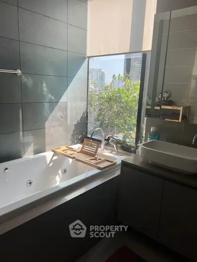 Luxurious bathroom with city view and modern bathtub in high-rise apartment.