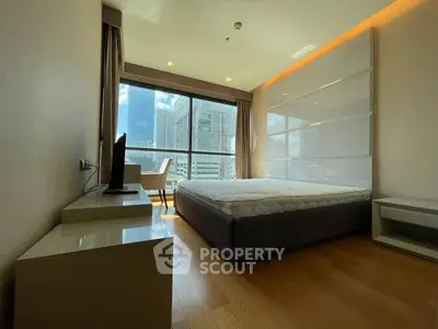 Modern bedroom with city view and sleek furnishings in high-rise apartment