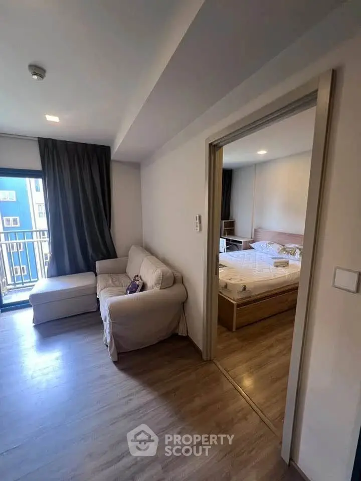 Modern apartment interior with cozy living room and bedroom, featuring a balcony view.