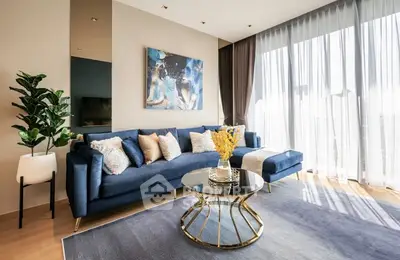 Luxurious modern living room with elegant blue sofa and floor-to-ceiling windows.