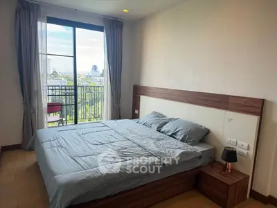 Spacious bedroom with modern decor and balcony view in urban apartment